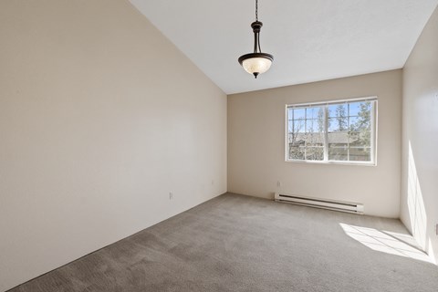 the living room of an empty house with a large window