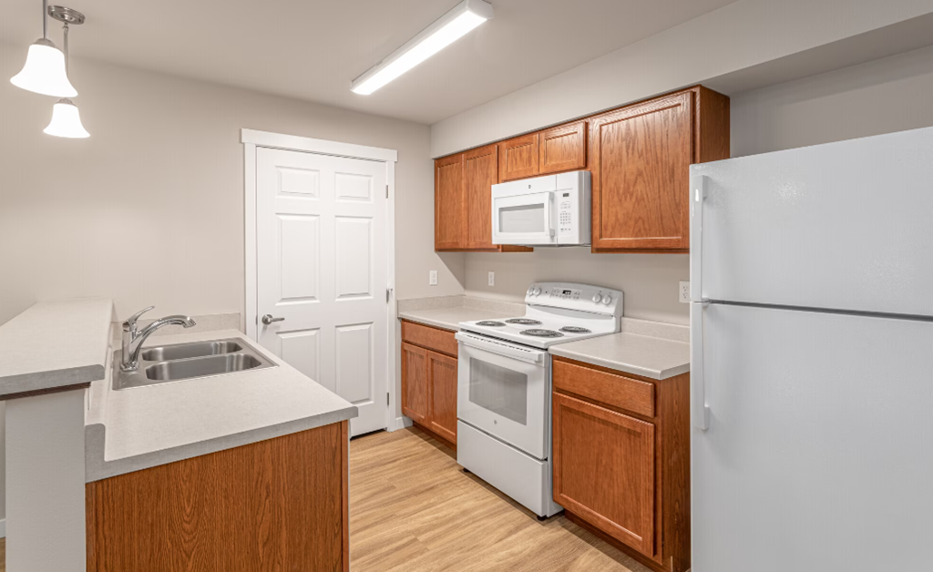 a kitchen with white appliances and wooden cabinets