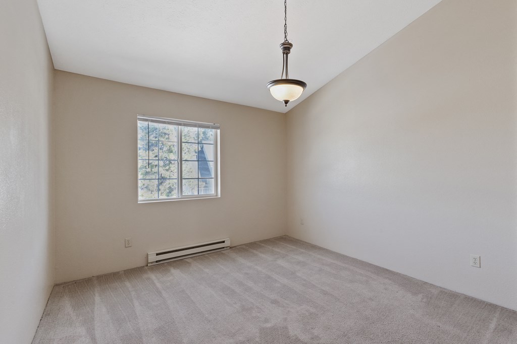 an empty room with white walls and a window
