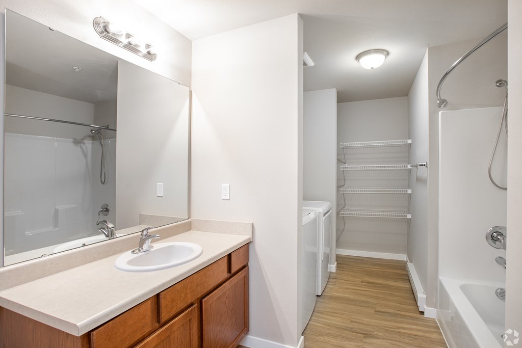 a bathroom with a large mirror and a shower and a sink