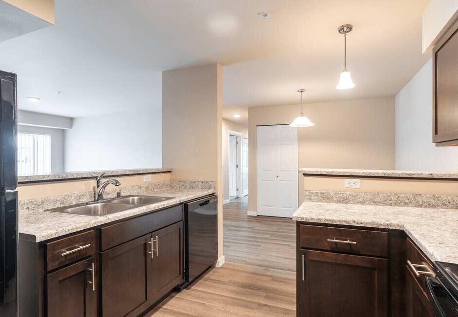 a kitchen with wooden cabinets and granite counter tops and a sink