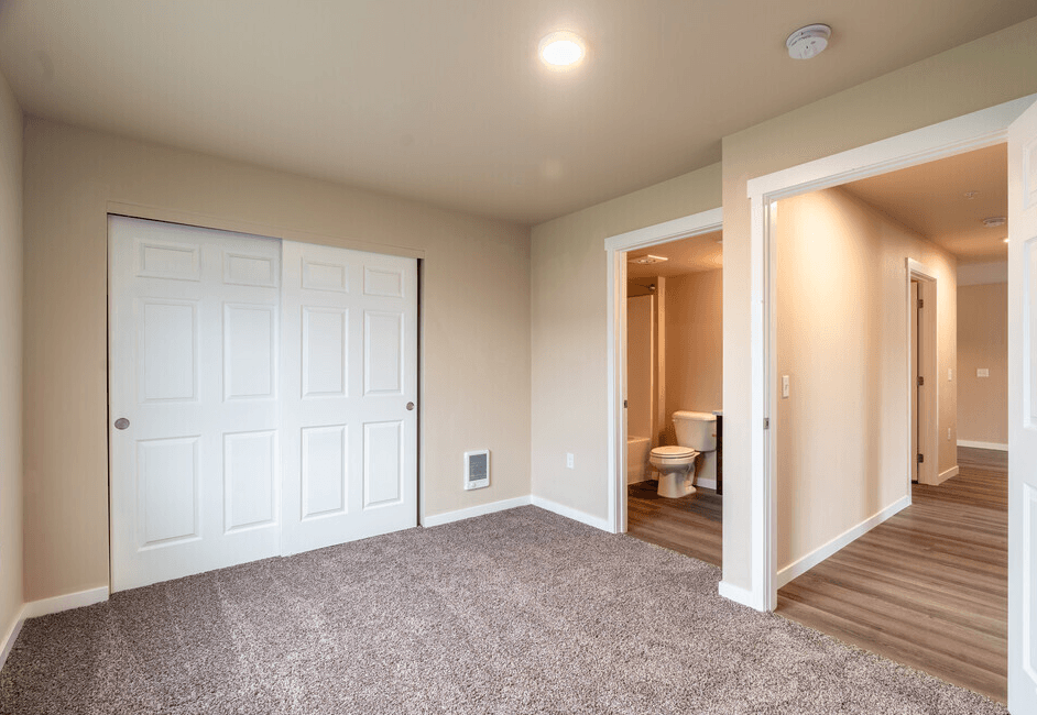 a bedroom with a closet and a door to a bathroom