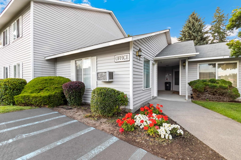 A grey building with a sign that says leasing office
