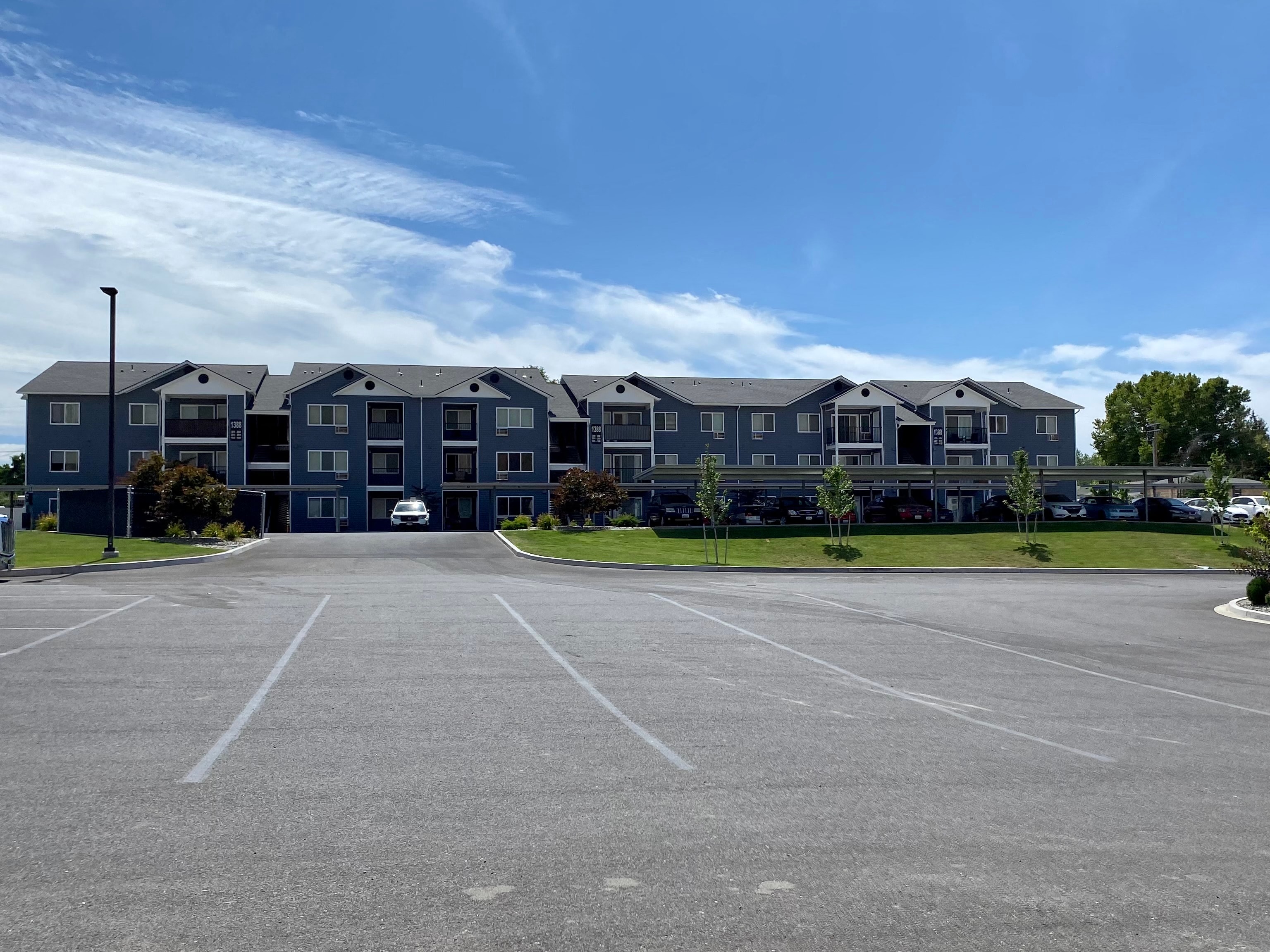 an empty parking lot in front of an apartment building