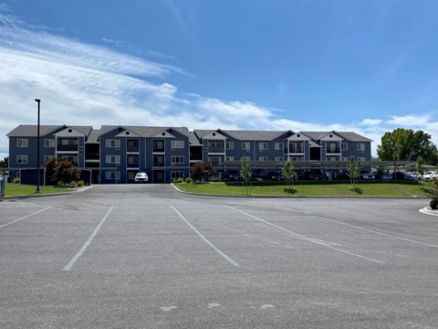 an empty parking lot in front of an apartment building