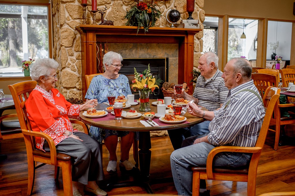 a group of people sitting around a table eating food