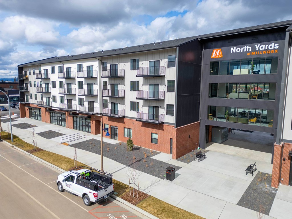 A white truck is parked in front of a building with a sign that says North Yards.
