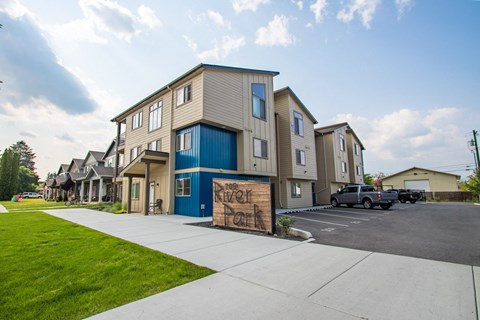 a sign sits on the sidewalk in front of a row of houses