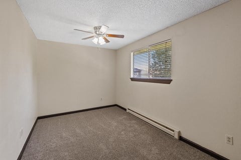 the living room of a home with a ceiling fan and a window