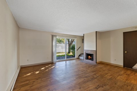 an empty living room with a fireplace and a sliding glass door