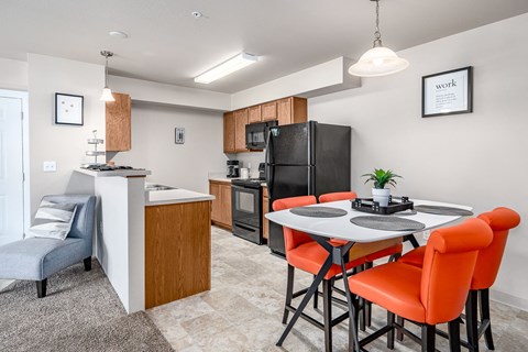 a kitchen and dining area with a table and chairs and a refrigerator
