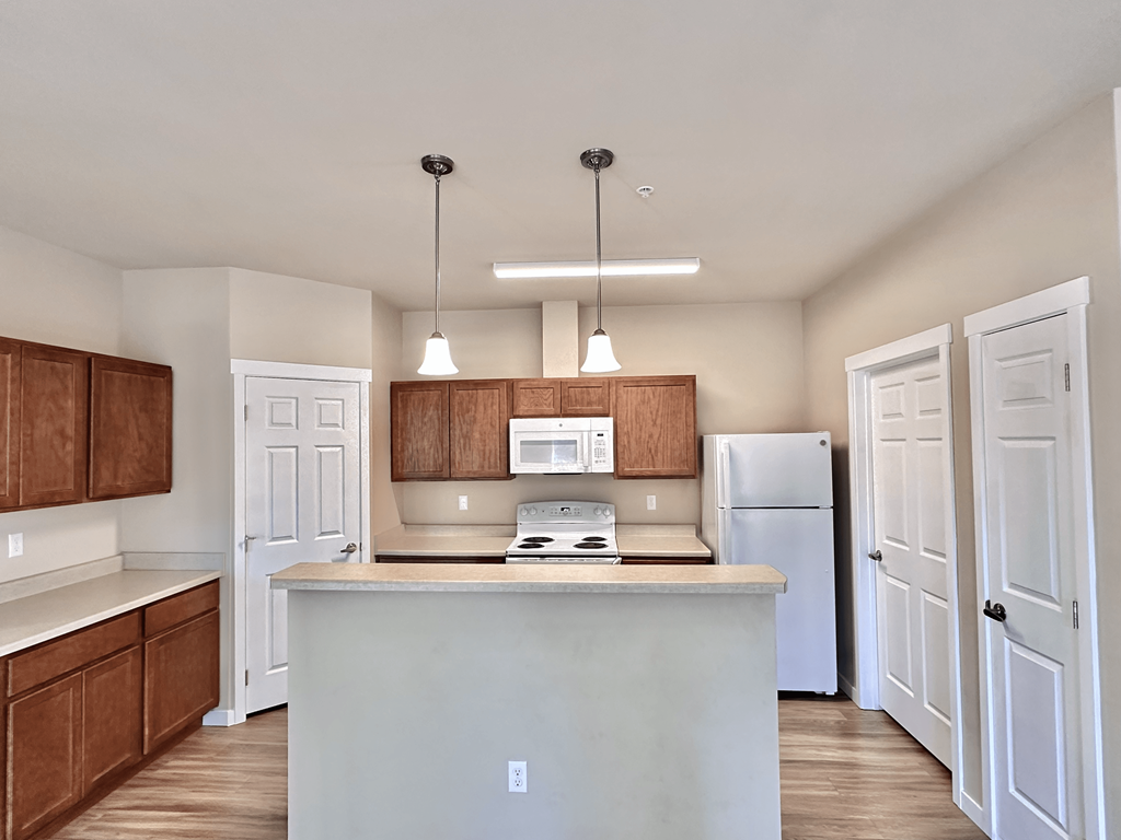 A kitchen with white cabinets and a white fridge.