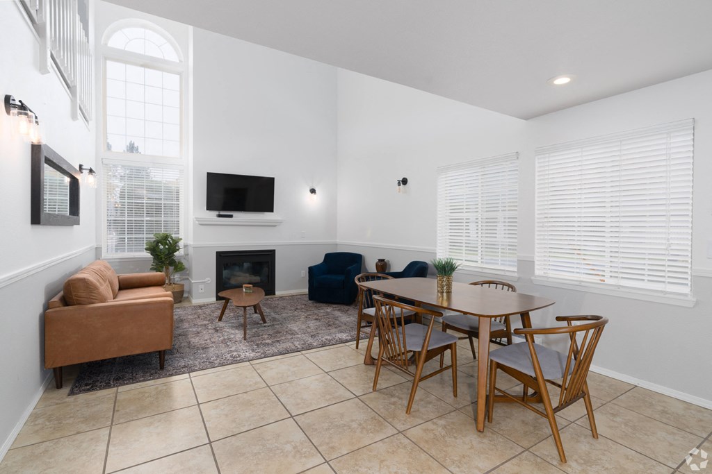a living room with a table and chairs and a fireplace