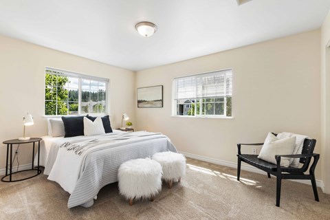 a bedroom with a bed and two windows