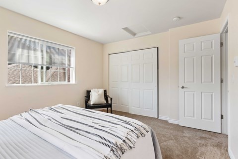 a bedroom with a bed and a closet and a window