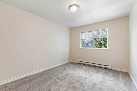 an empty room with carpet and a window
