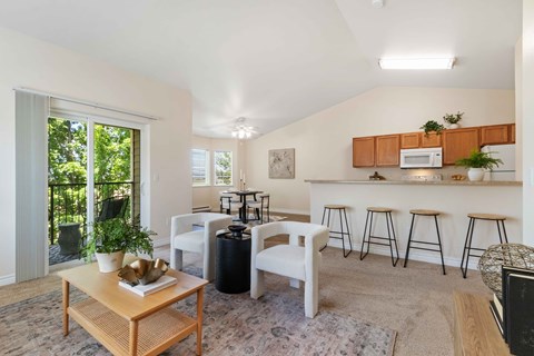a living room with a island bar and a kitchen with stools
