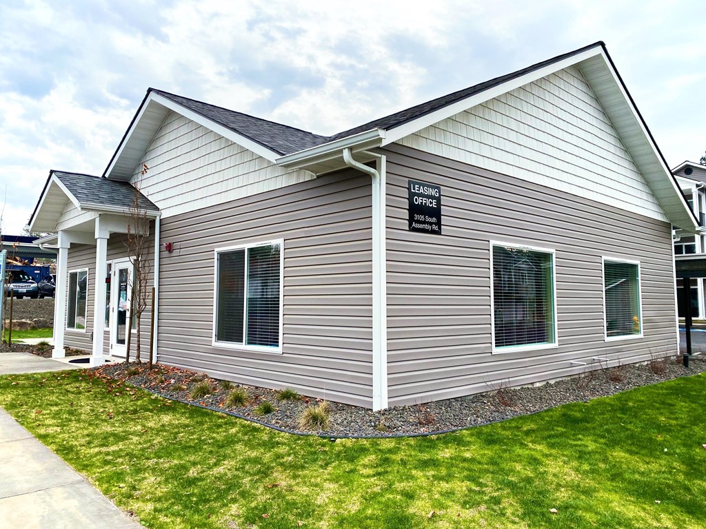 the front of a house with a lawn and a sidewalk