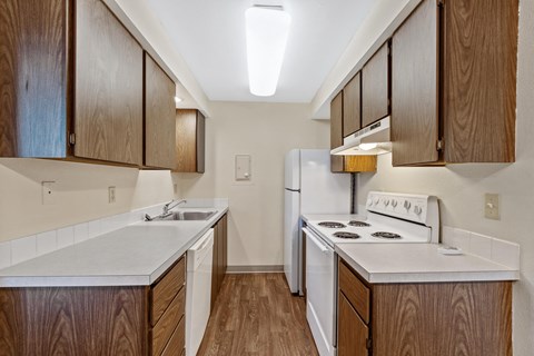 the preserve at ballantyne commons apartment kitchen with white appliances and wooden cabinets