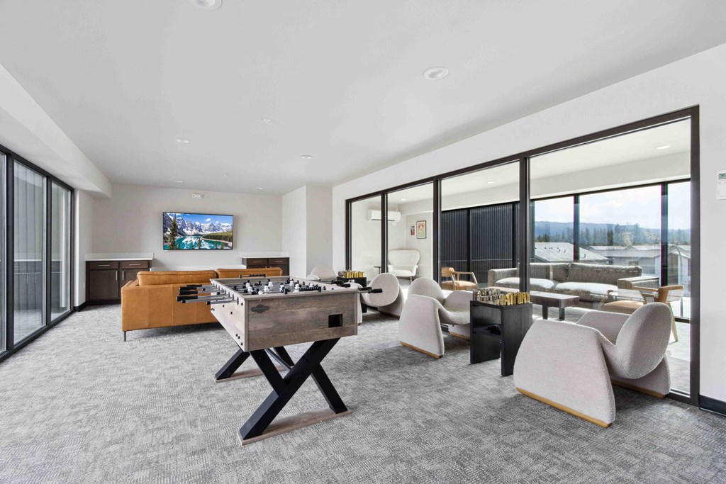 A room with a foosball table and a couch.