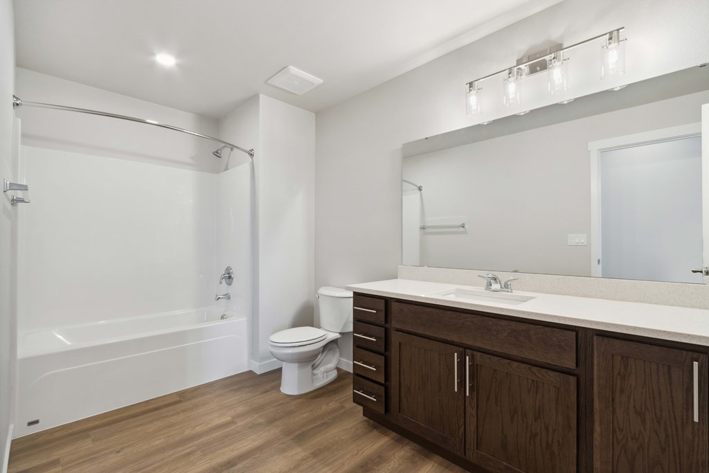A white bathroom with a toilet, sink, and bathtub.