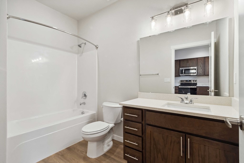 A white bathroom with a toilet, sink, and a mirror.