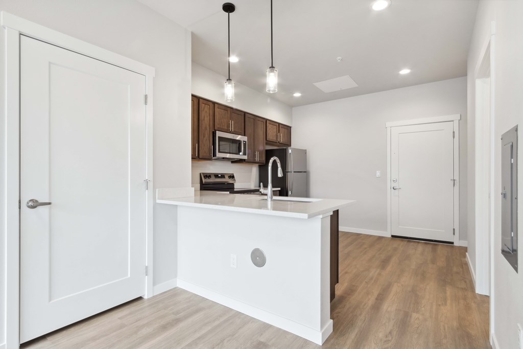 A kitchen with white cabinets and a white island.