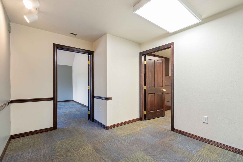 a empty room with a door to a hallway and a closet