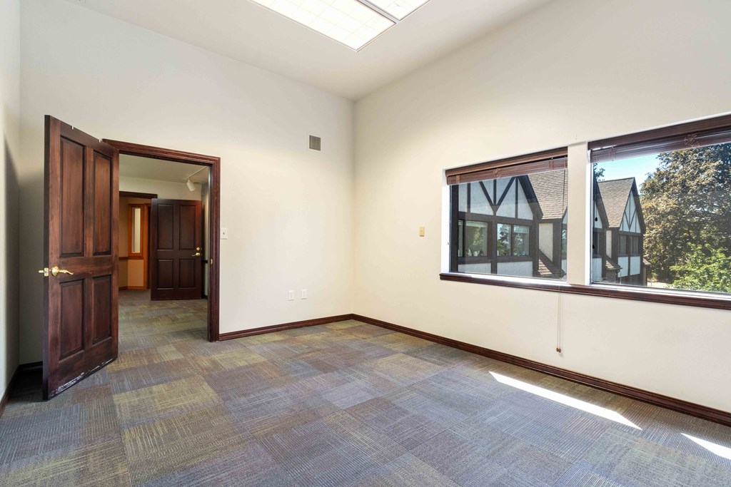 an empty living room with a large window and a door