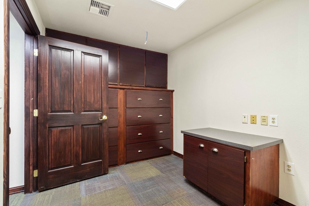 a laundry room with wooden cabinets and a counter