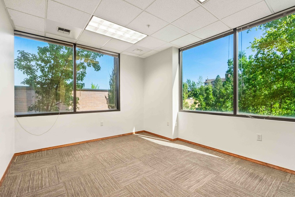 an empty room with three large windows