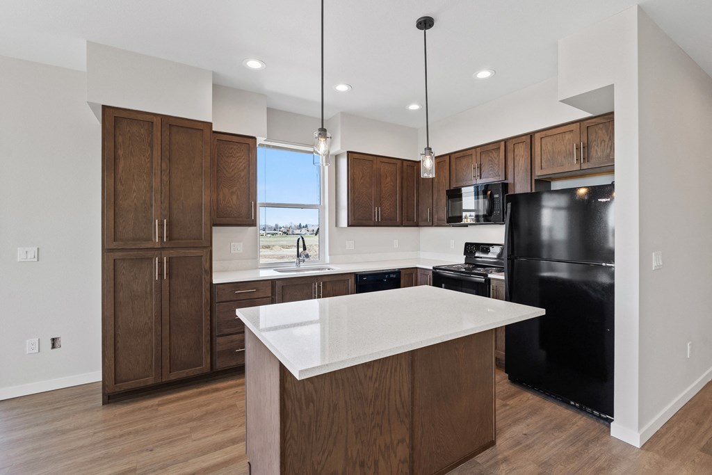 a large kitchen with a white counter top and black appliances