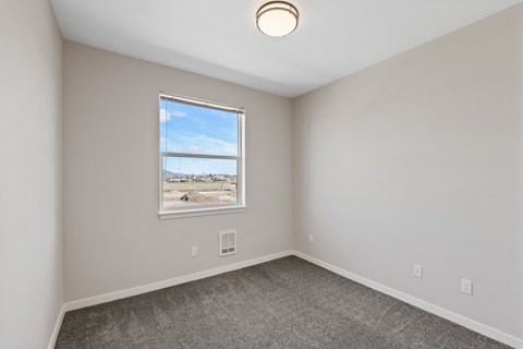 an empty room with carpet and a window