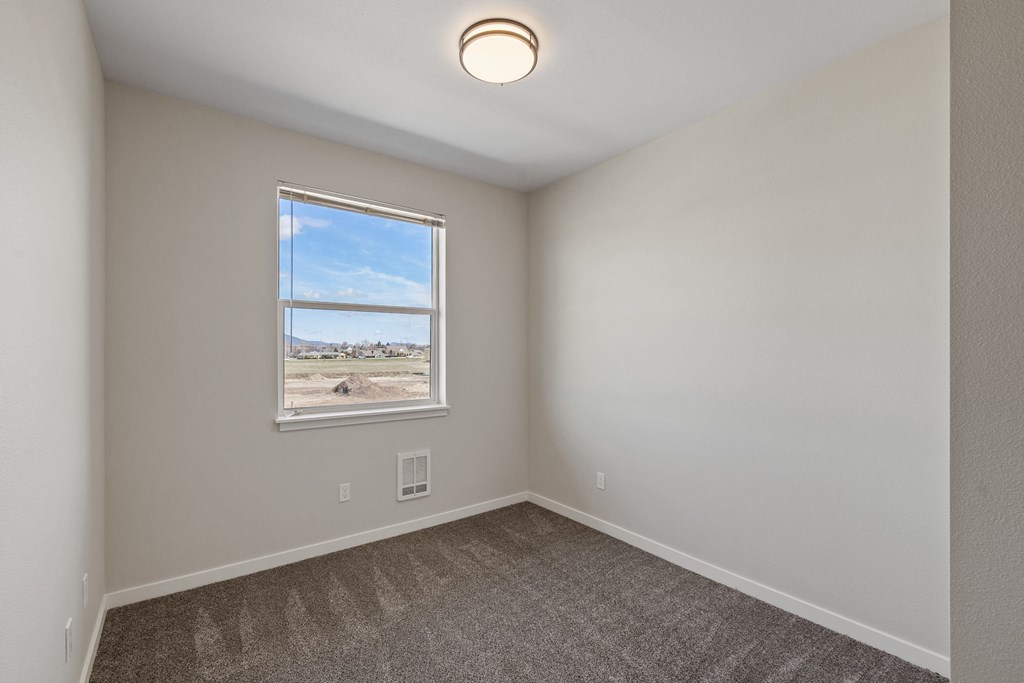 an empty room with carpet and a window