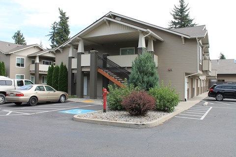 a building with a parking lot and cars in front of it