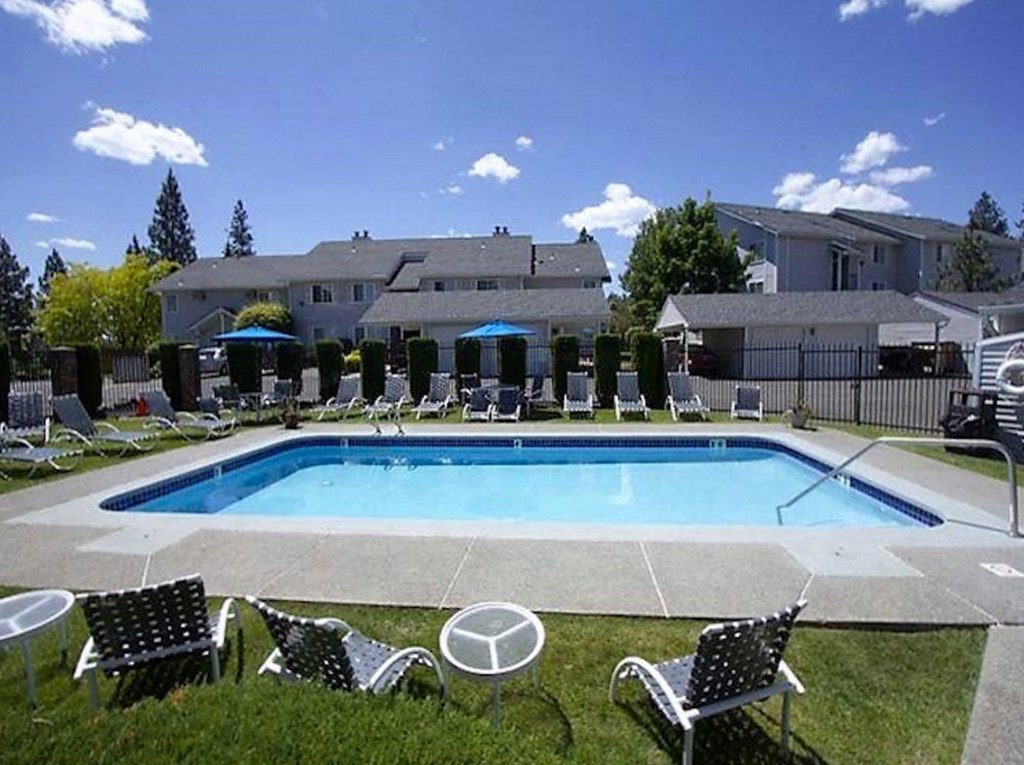 a swimming pool with chairs and chairs around it