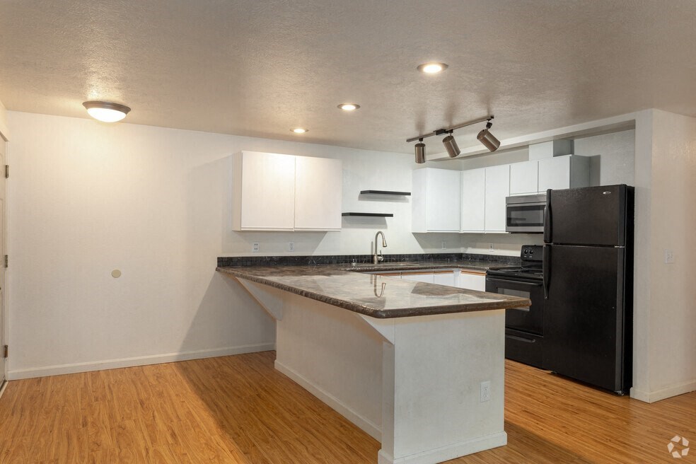 a kitchen with an island and a black refrigerator