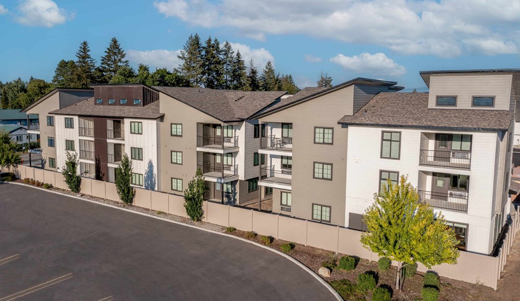 an exterior view of an apartment building with a road in front of it