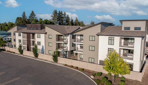 an exterior view of an apartment building with a road in front of it
