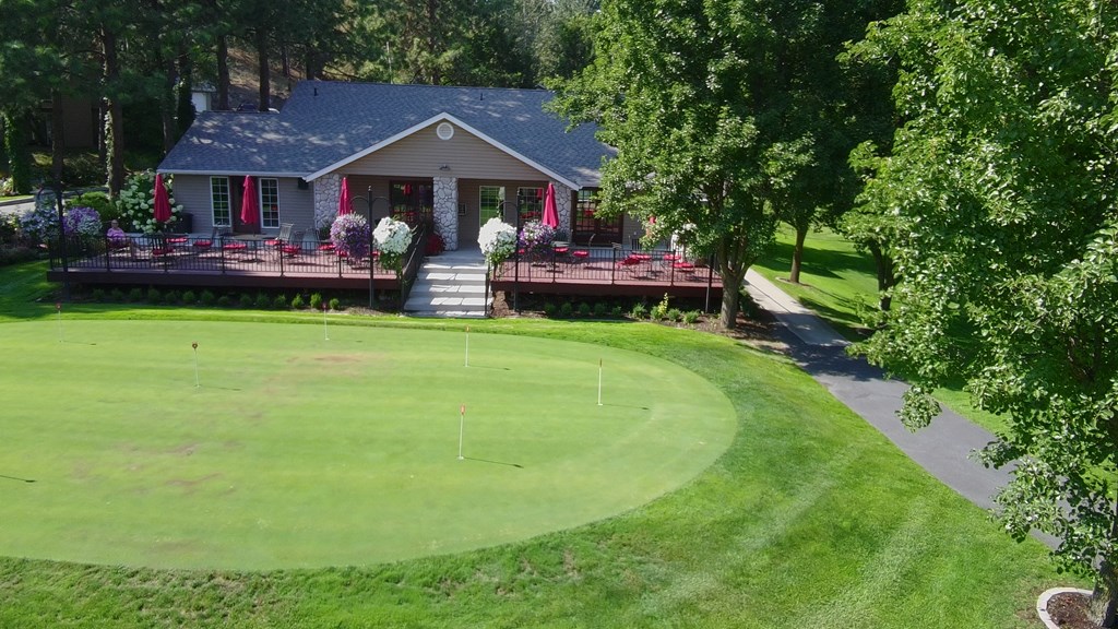 A house with a green lawn in front of it.