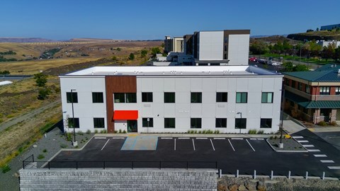 A modern building with a parking lot in front.