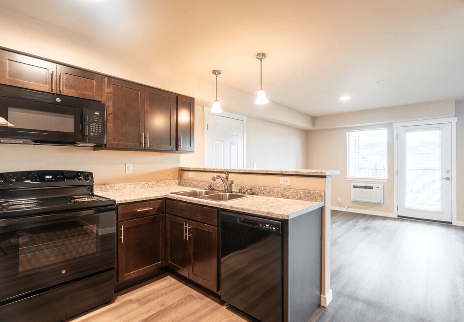 an empty kitchen with black appliances and wood cabinets