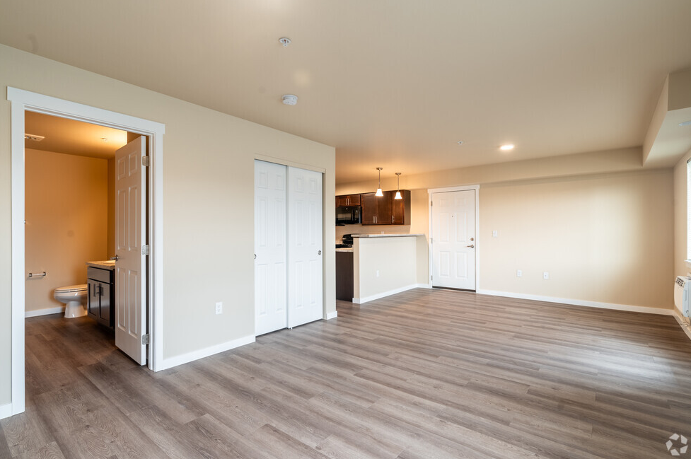 a living room with a wood floor and a kitchen