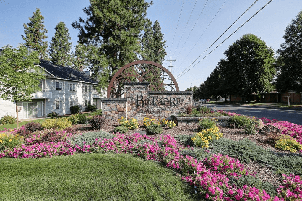 Biltmore-Beaumont Apartments a sign that reads Biltmore Apartments in front of a garden with flowers
