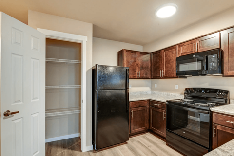 a kitchen with black appliances and wooden cabinets