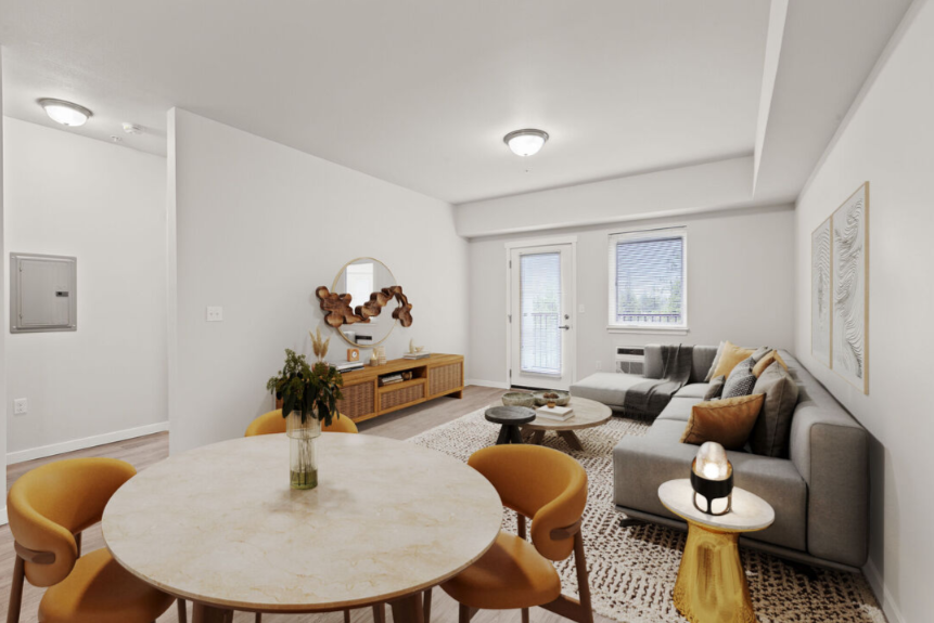 A modern living room with a round table and yellow chairs.