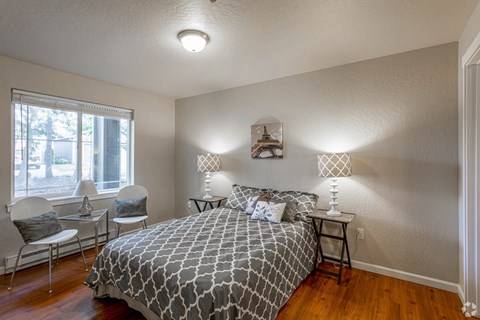 a bedroom with a bed and two lamps and a window