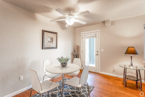 a dining room with a table and chairs and a ceiling fan