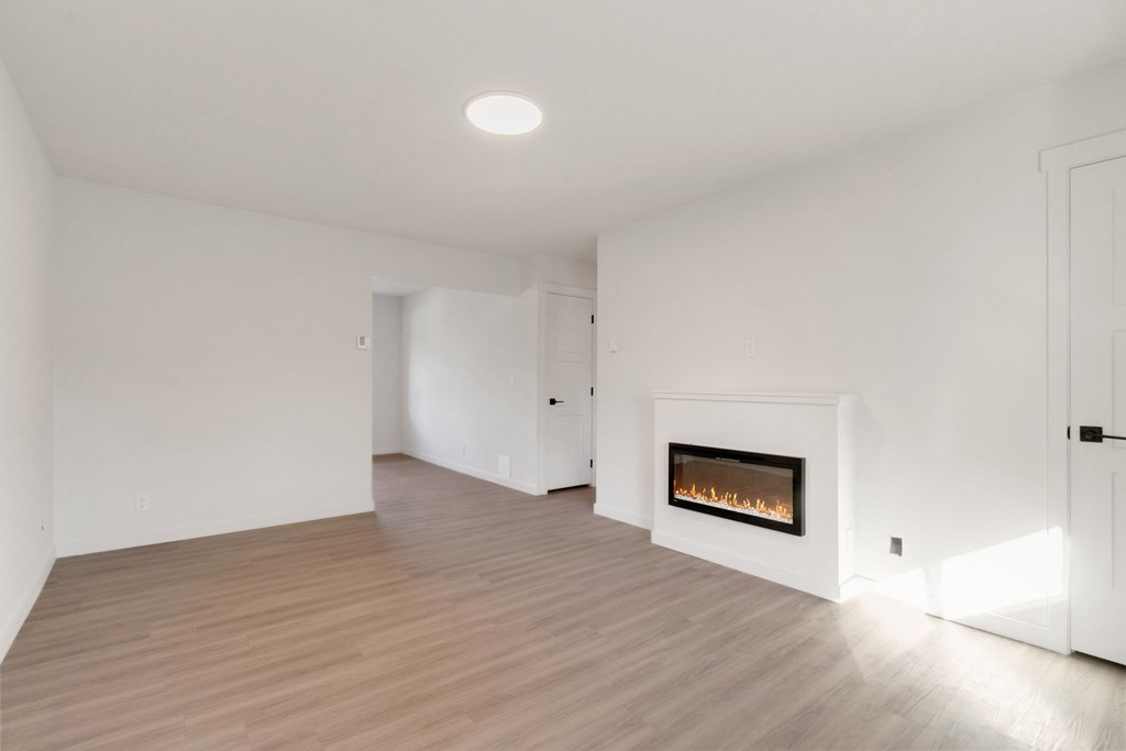 a living room with white walls and a fireplace