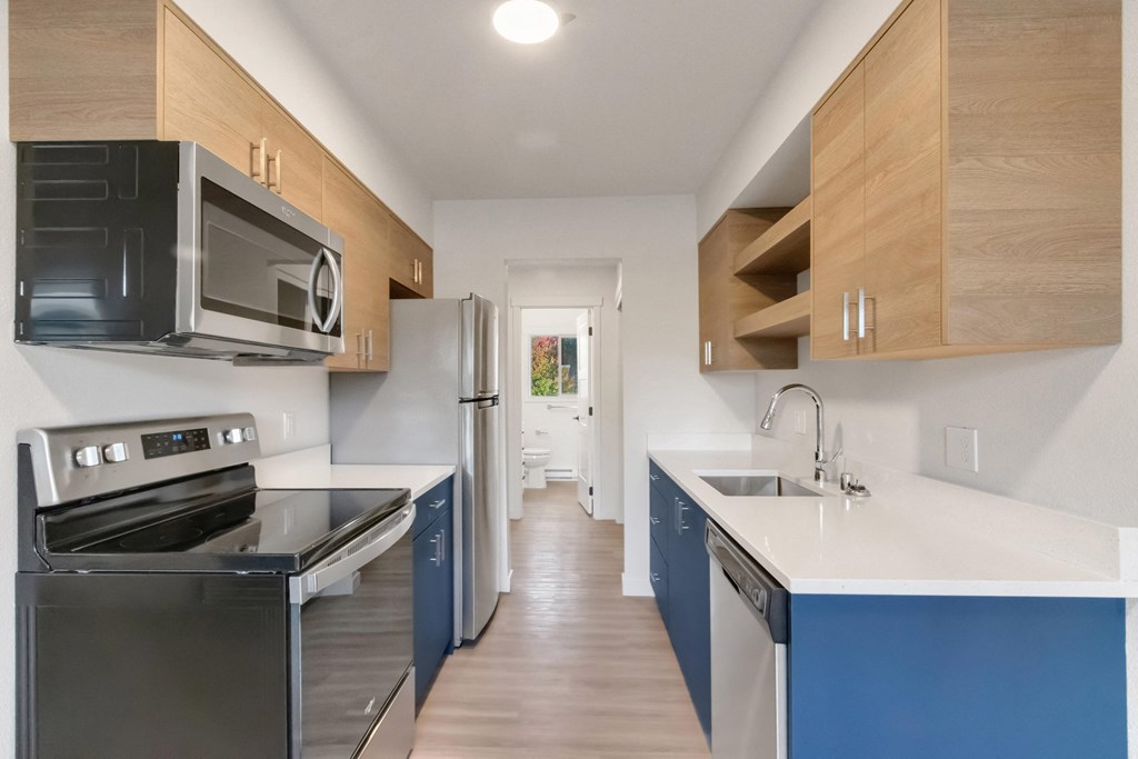 a kitchen with blue cabinets and stainless steel appliances and a white counter top
